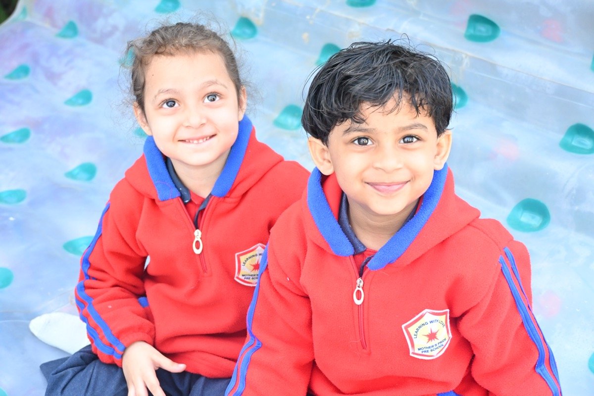 Happy Children in front of Mother's Pride school building